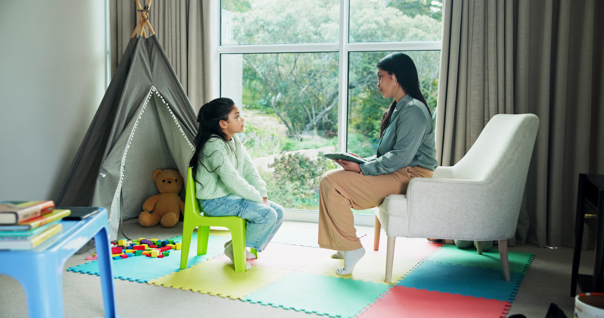 A therapist with a child in a colorful playroom