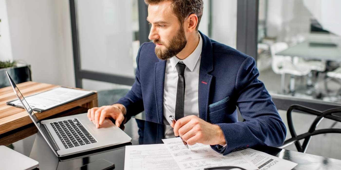 Tax professional at office desk for "How to Stop Wasting Time Chasing Clients in MTD" blog post by ClientWindow