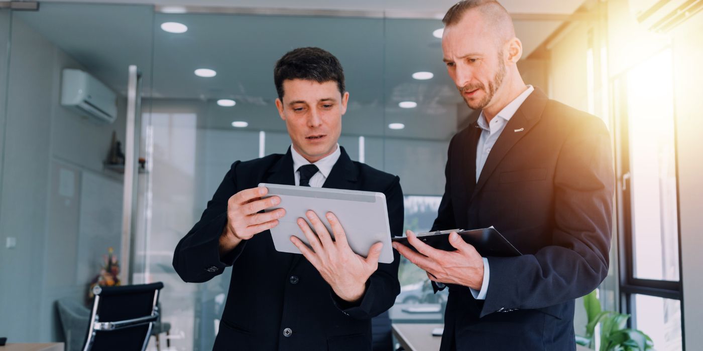Two men looking over information on mobile devices