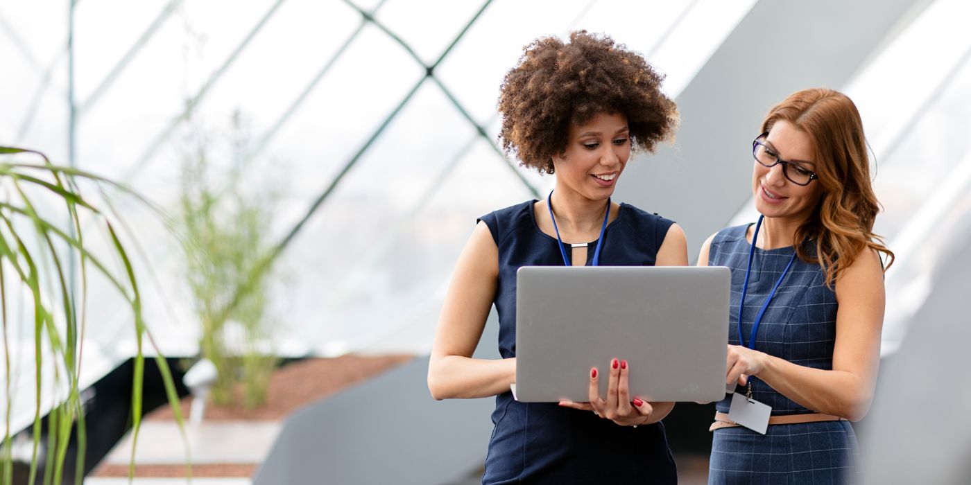 Two female colleagues and a laptop in office