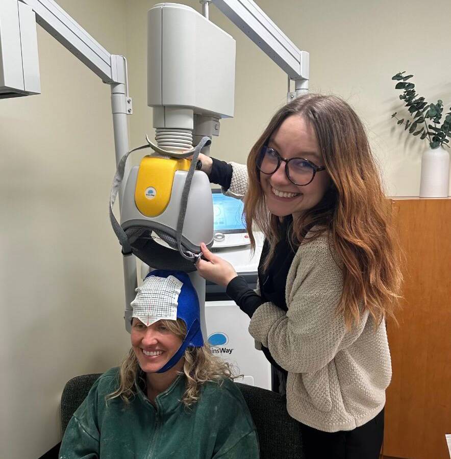 TMS machine in use, showing treatment room and care team