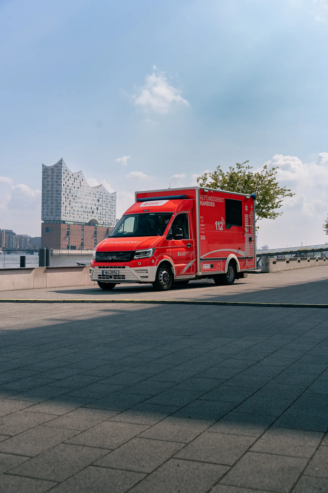 Elektrische Ambulanz auf Basis MAN TGE mit Kofferaufbau, im Hintergrund die Elbphilharmonie