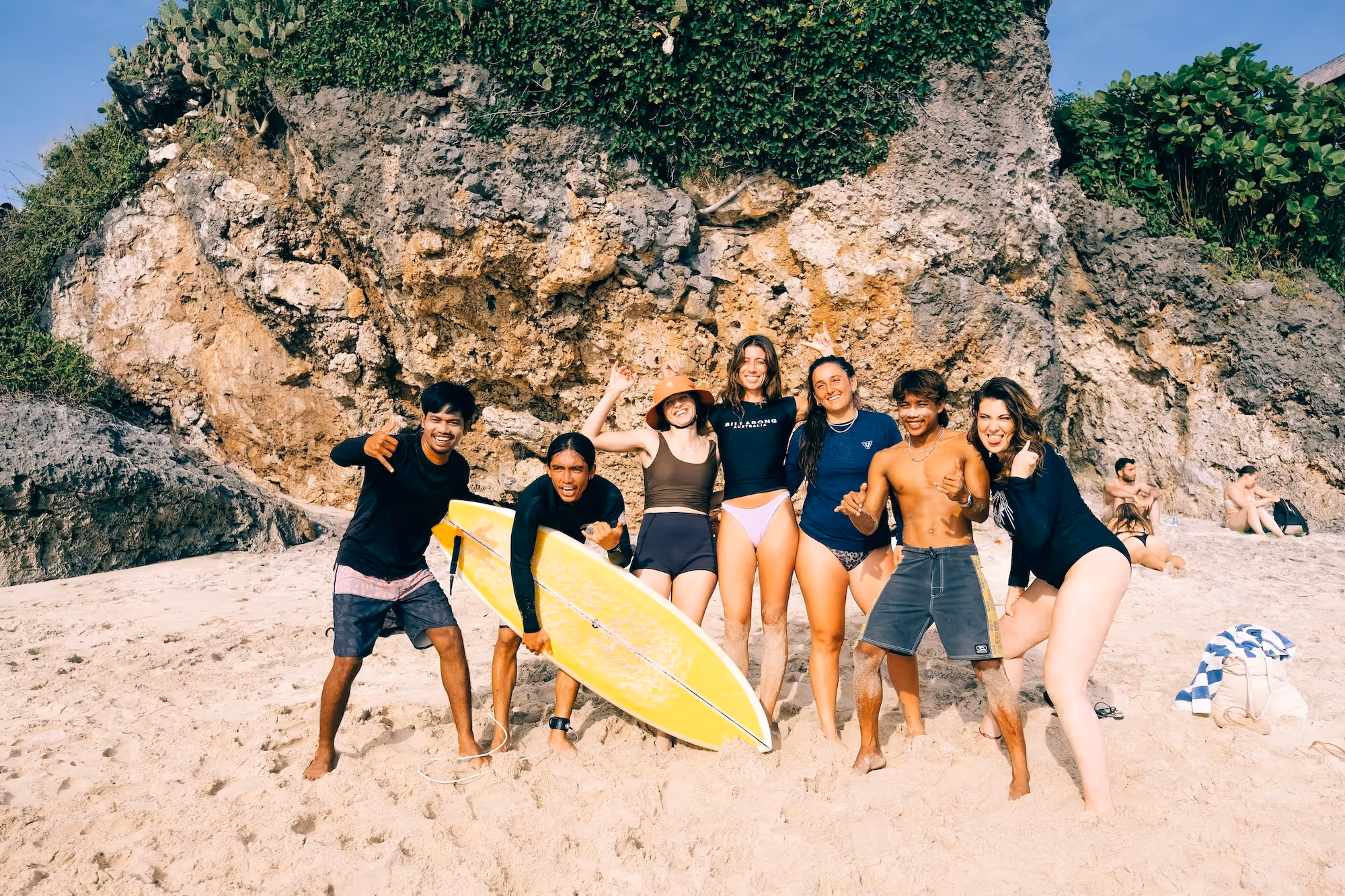 Kala Surf Camp guests and coaches with surfboards on a beach in Uluwatu