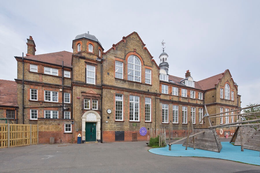 Stroud Green Primary School yellow-brick elevation, white sash windows and playground, London