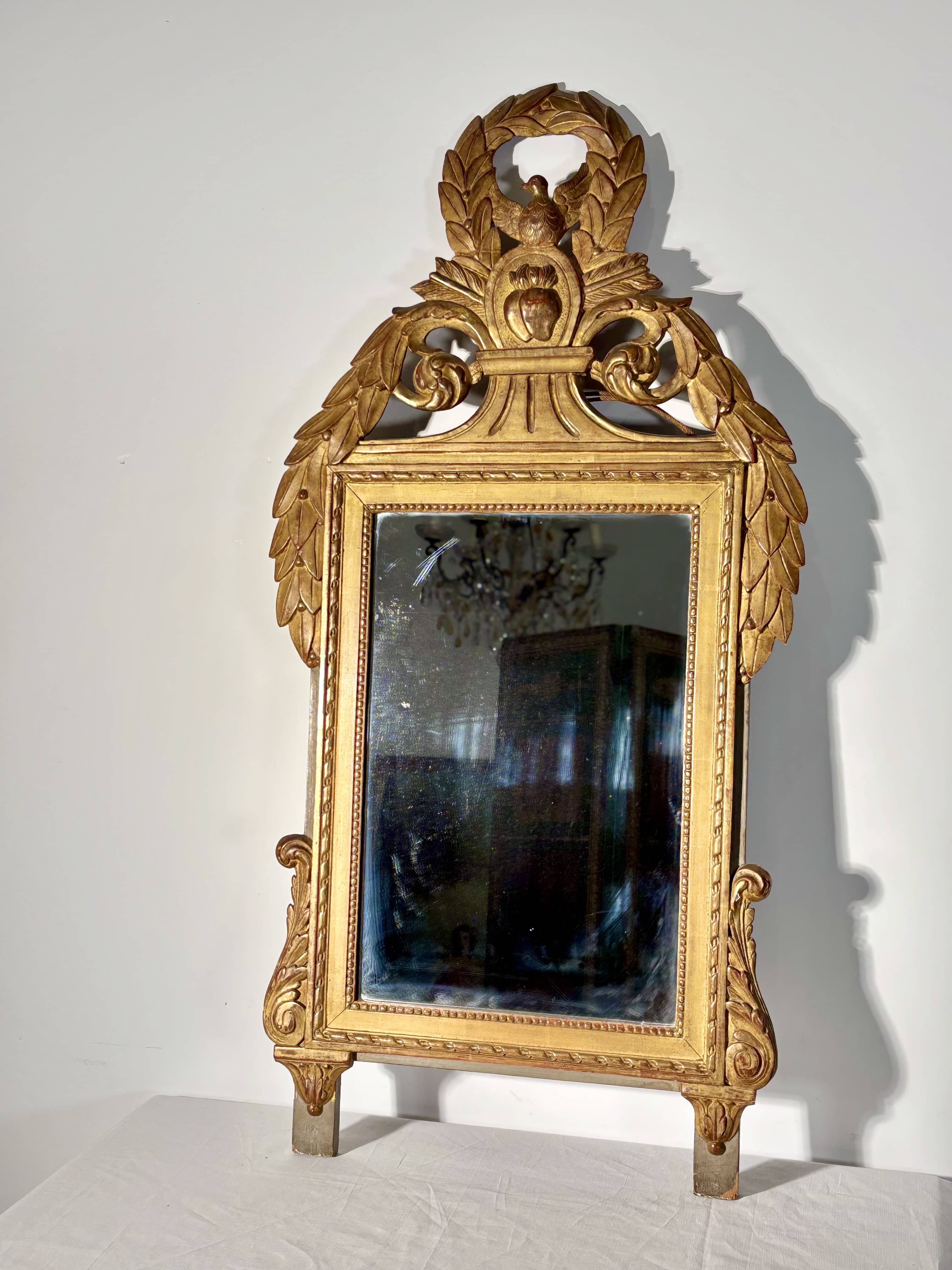 Miroir à fronton de style Louis XVI en bois sculpté doré, fin XVIIIe siècle