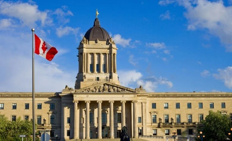 Graphic showing the Canadian flag flying in front of a government building, representing payroll services and employment regulations in Canada for 2026.