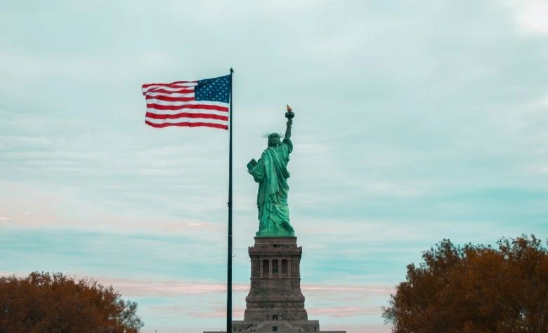 Graphic showing the Statue of Liberty and an American flag representing multi-state payroll processing. 