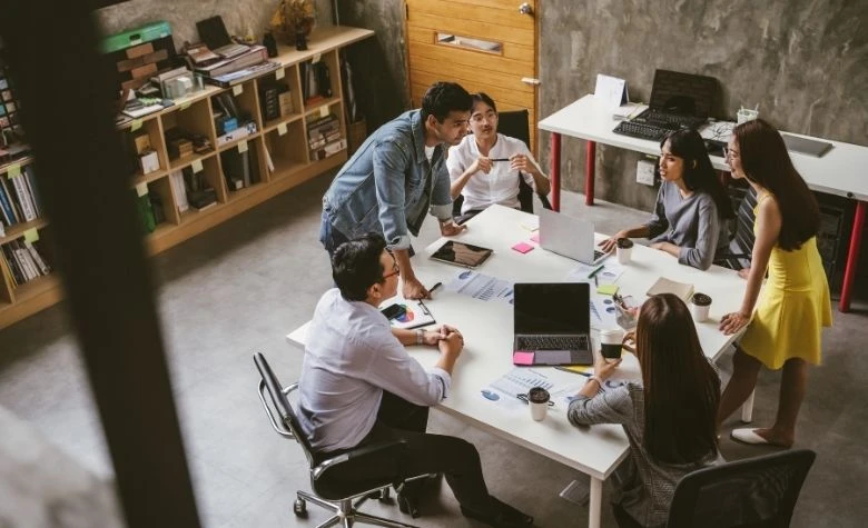 Graphic showing round-table collaboration for effective employee management. 