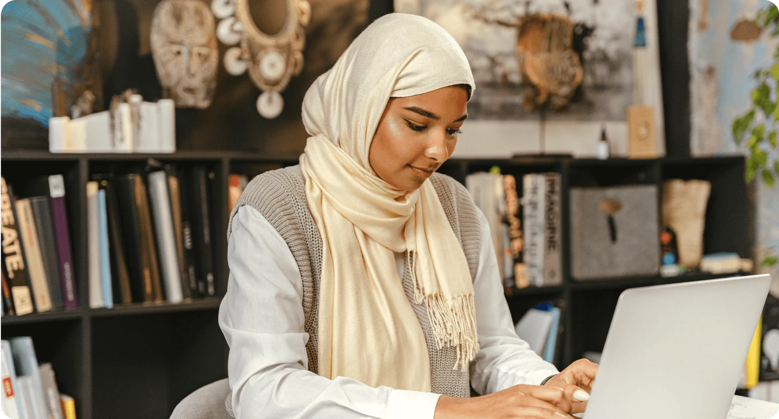 Woman working on a laptop, representing global team collaboration for hiring international employees