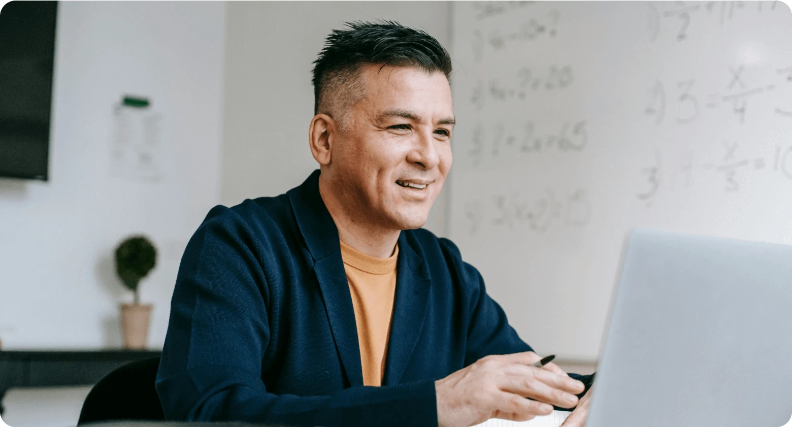  Professional man smiling and working on a laptop, representing global employment and remote work.
