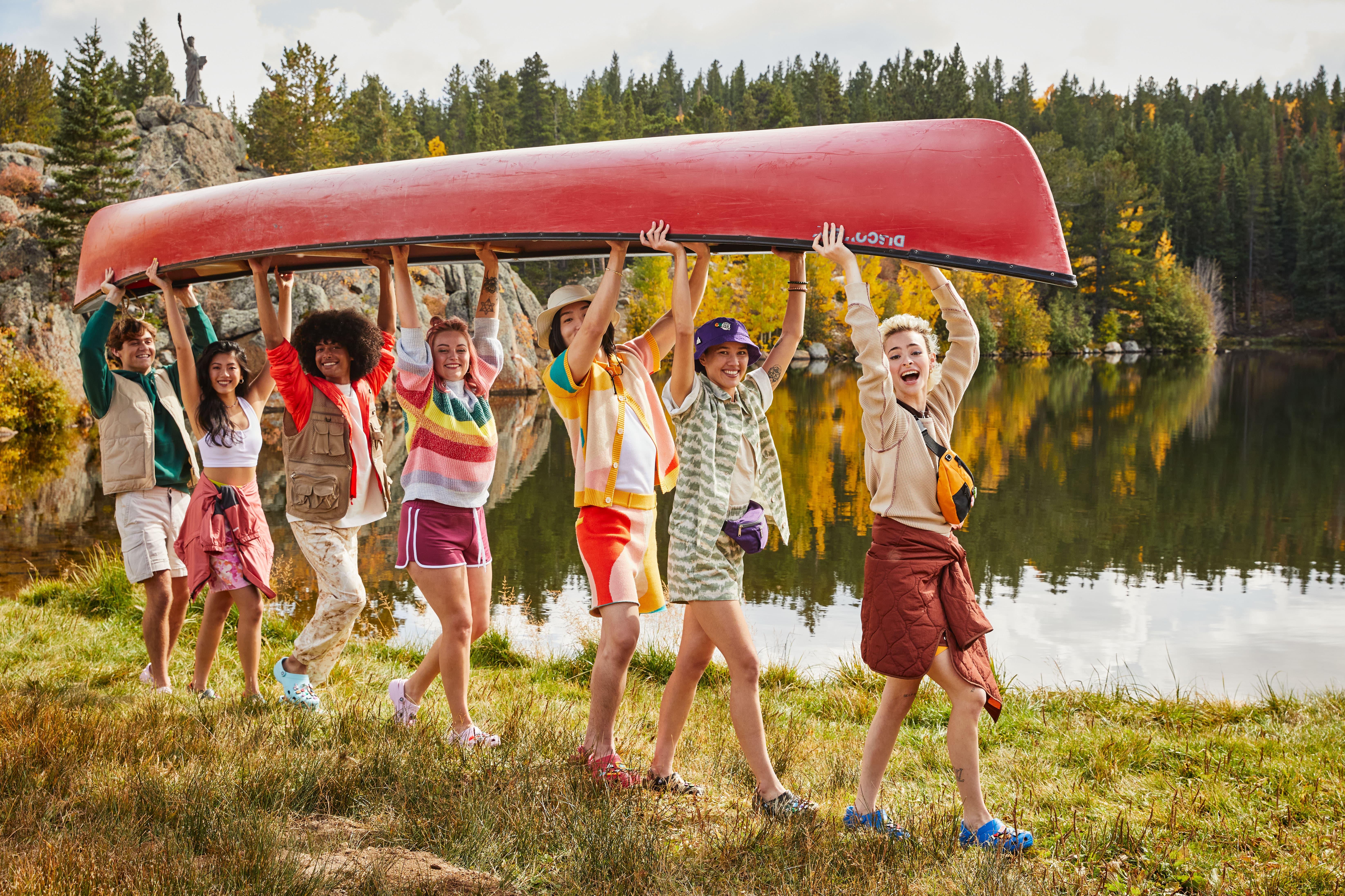 A group holding a canoe on the lake