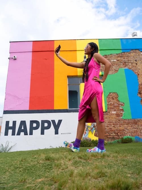 A colorful photo of a woman taking a selfie