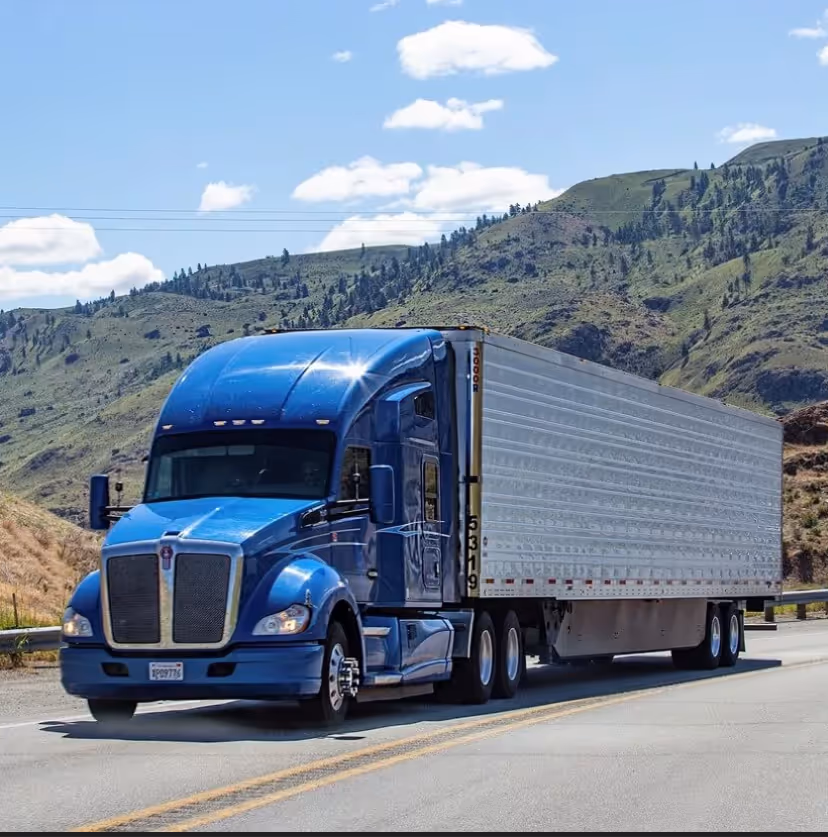 Blue Duka Transportation truck hauling a white trailer
