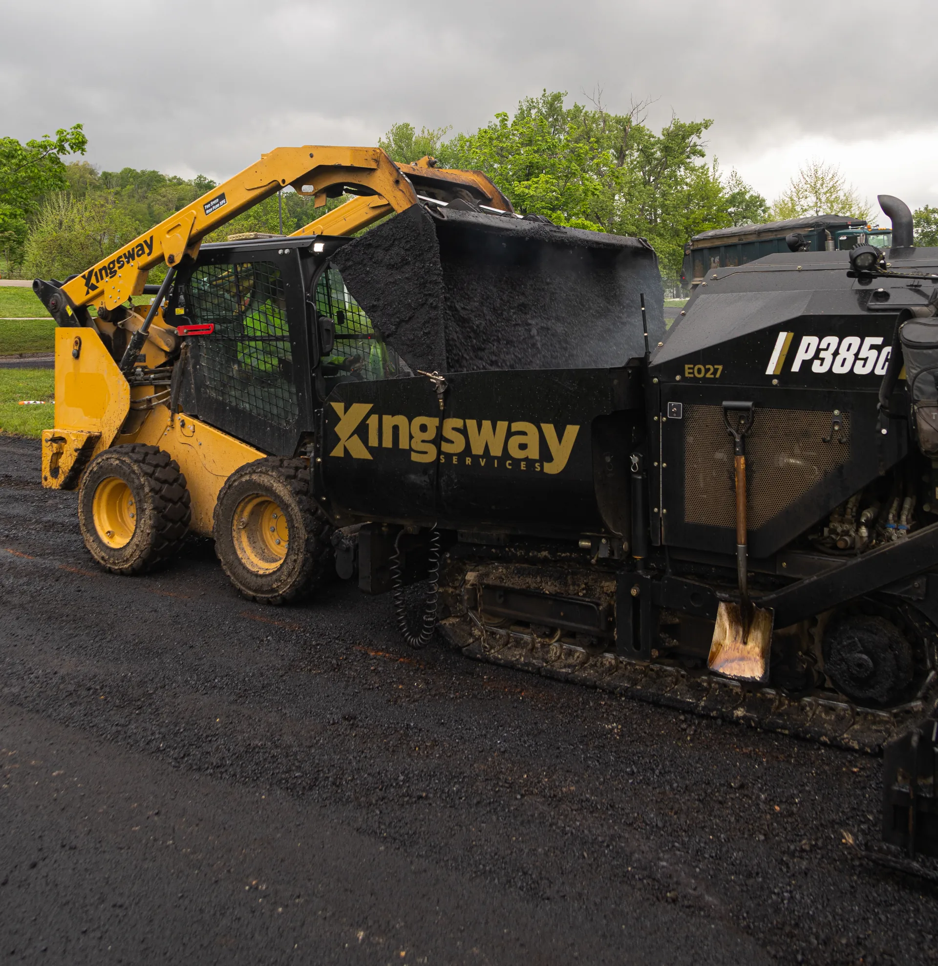 Kingsway Services asphalt paving crew using a skid steer and paving equipment to install fresh asphalt on a roadway