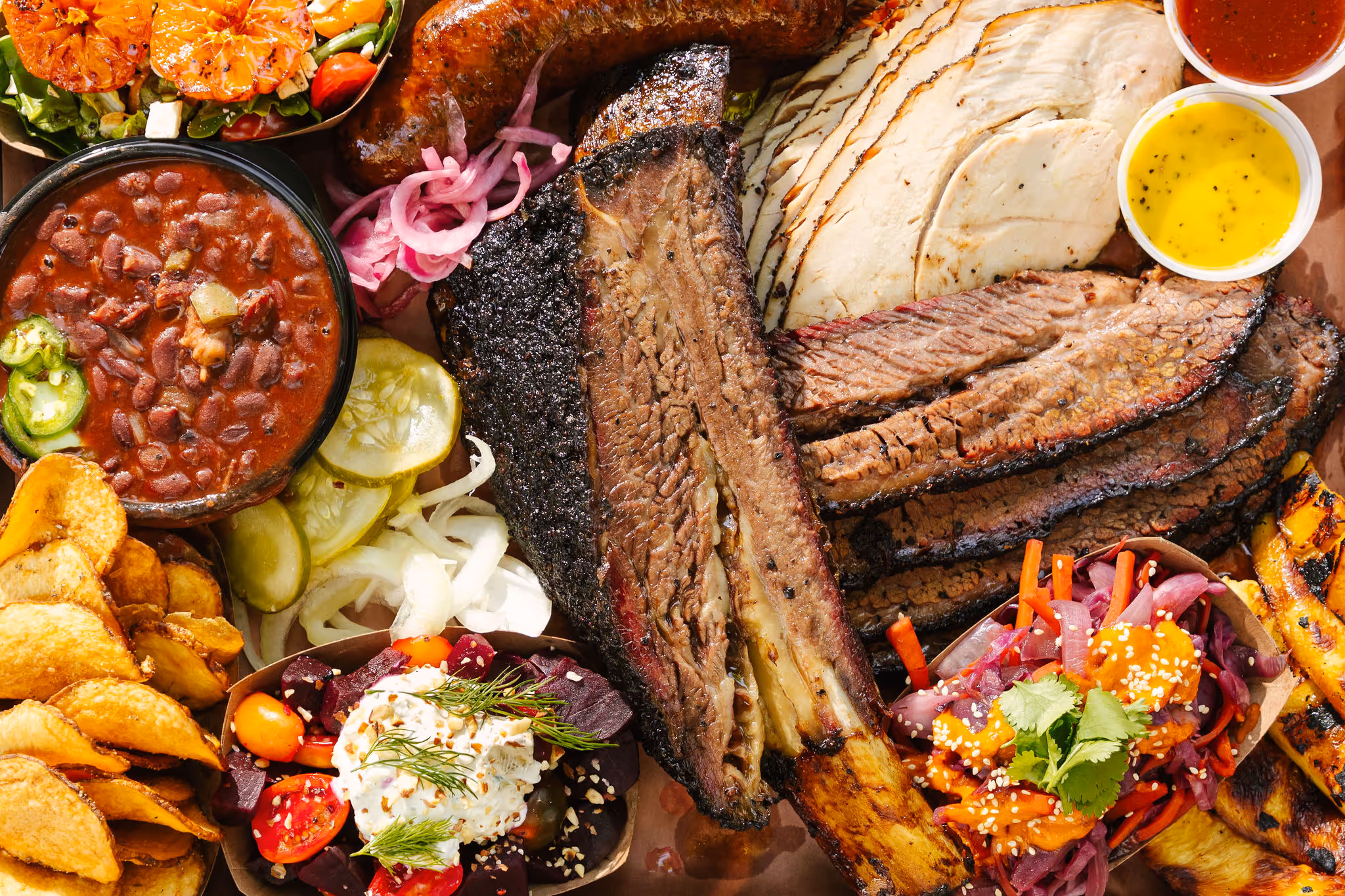 Brisket, beef rib, sausage, and vibrant sides on a BBQ tray at 2Fifty BBQ in Washington D.C. by Sophie Mac Photo.