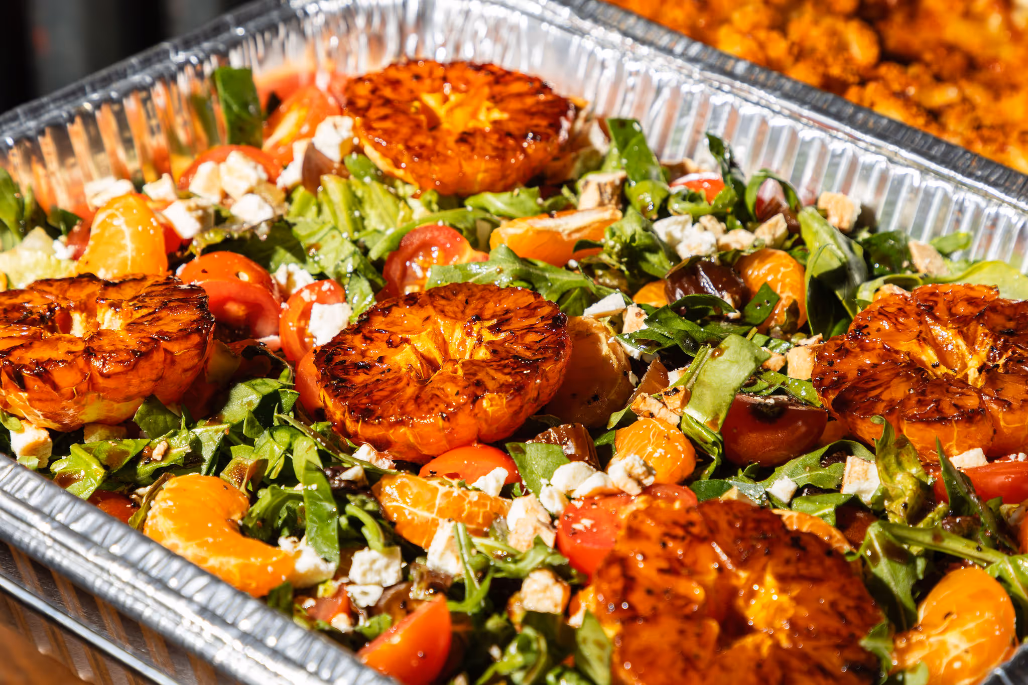 Grilled citrus salad with arugula, feta, cherry tomatoes, and mandarin slices at 2Fifty BBQ, Maryland.