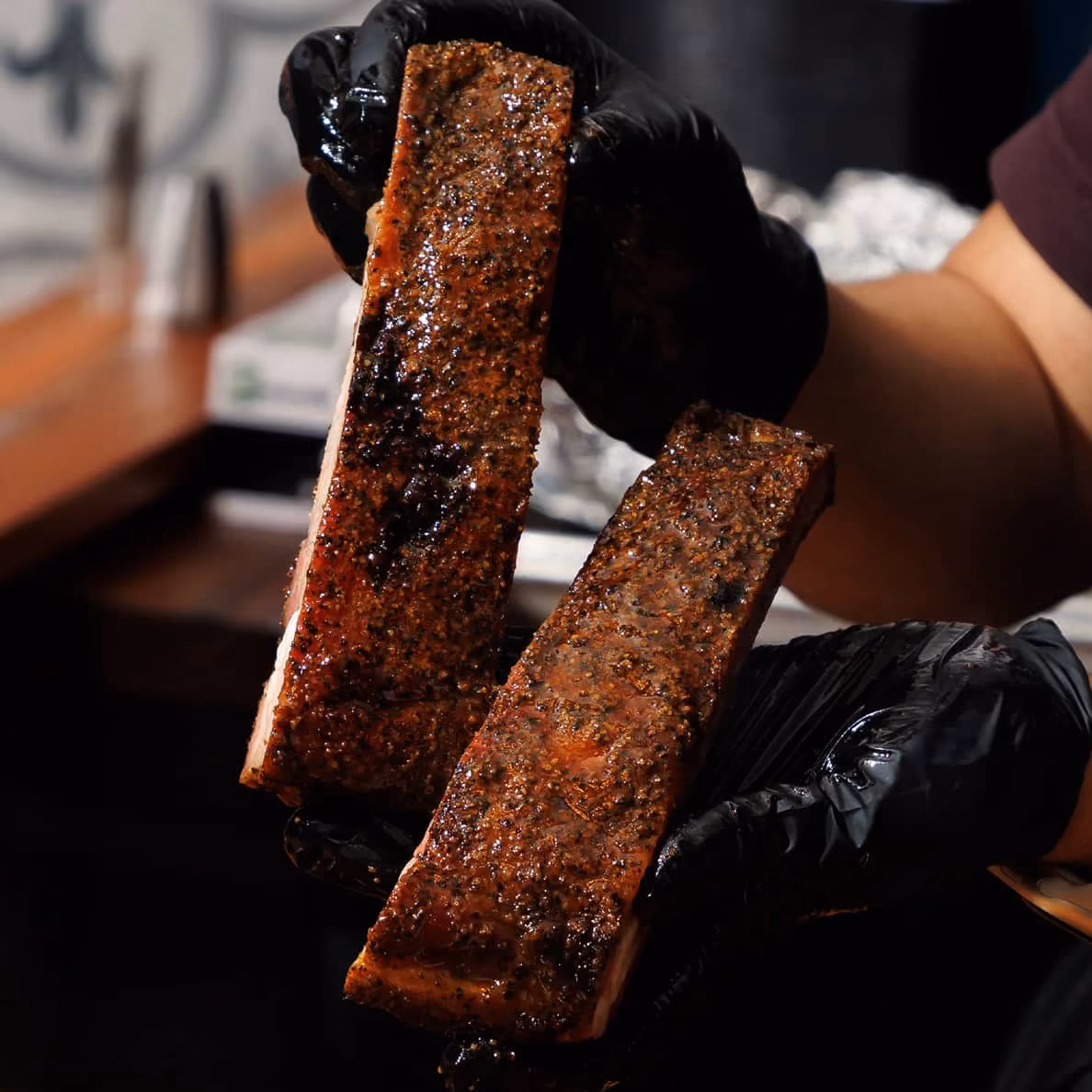 Pork spare ribs held close-up at 2Fifty BBQ, Texas-style wood-smoked barbecue