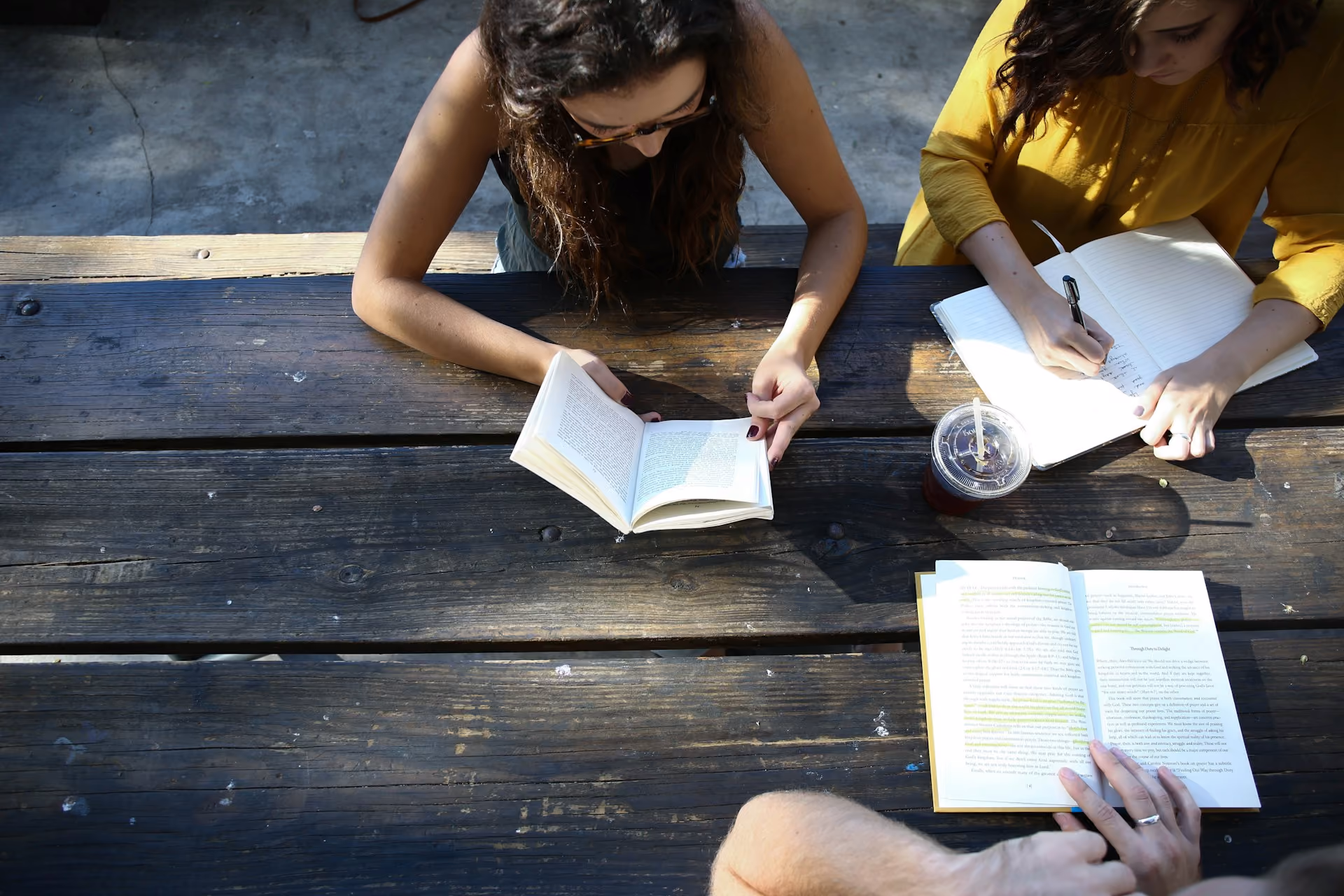 Des femmes lisant des livres à une table