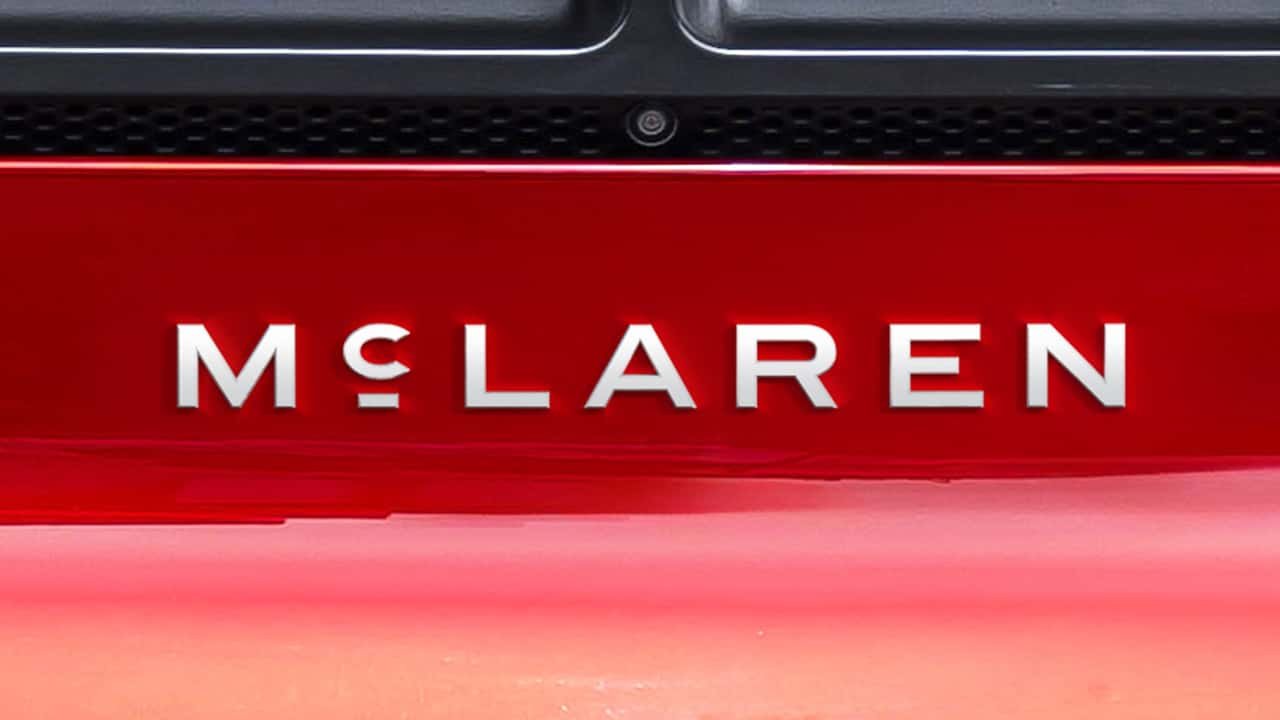 Close-up of the new McLaren wordmark badge on a red car