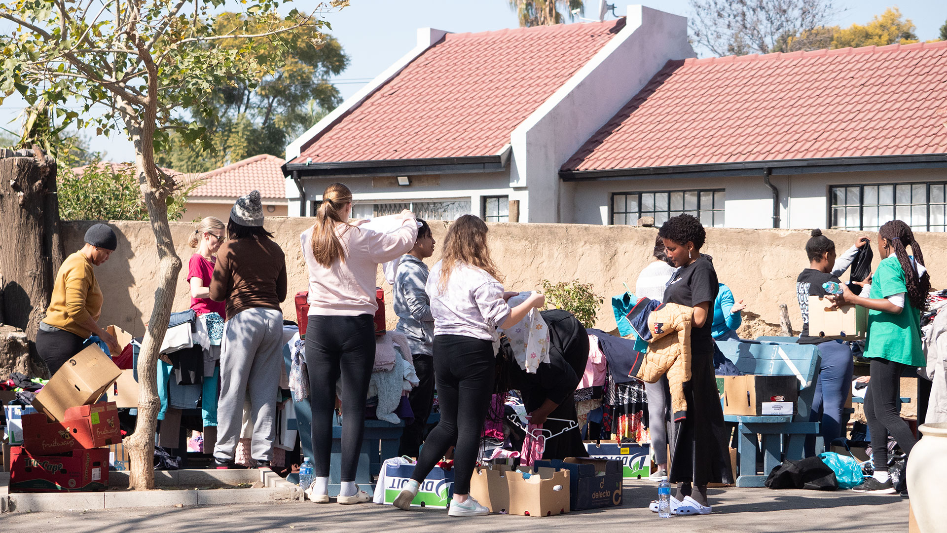 Group of Love Our City volunteers sorting donations outside.