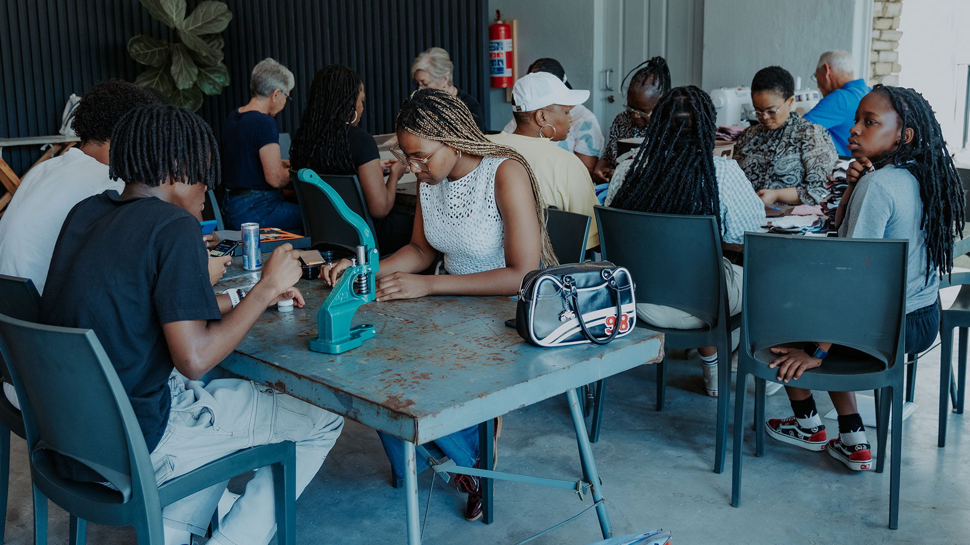 Love Our City volunteer sewing morning with several volunteers working at sewing machines.