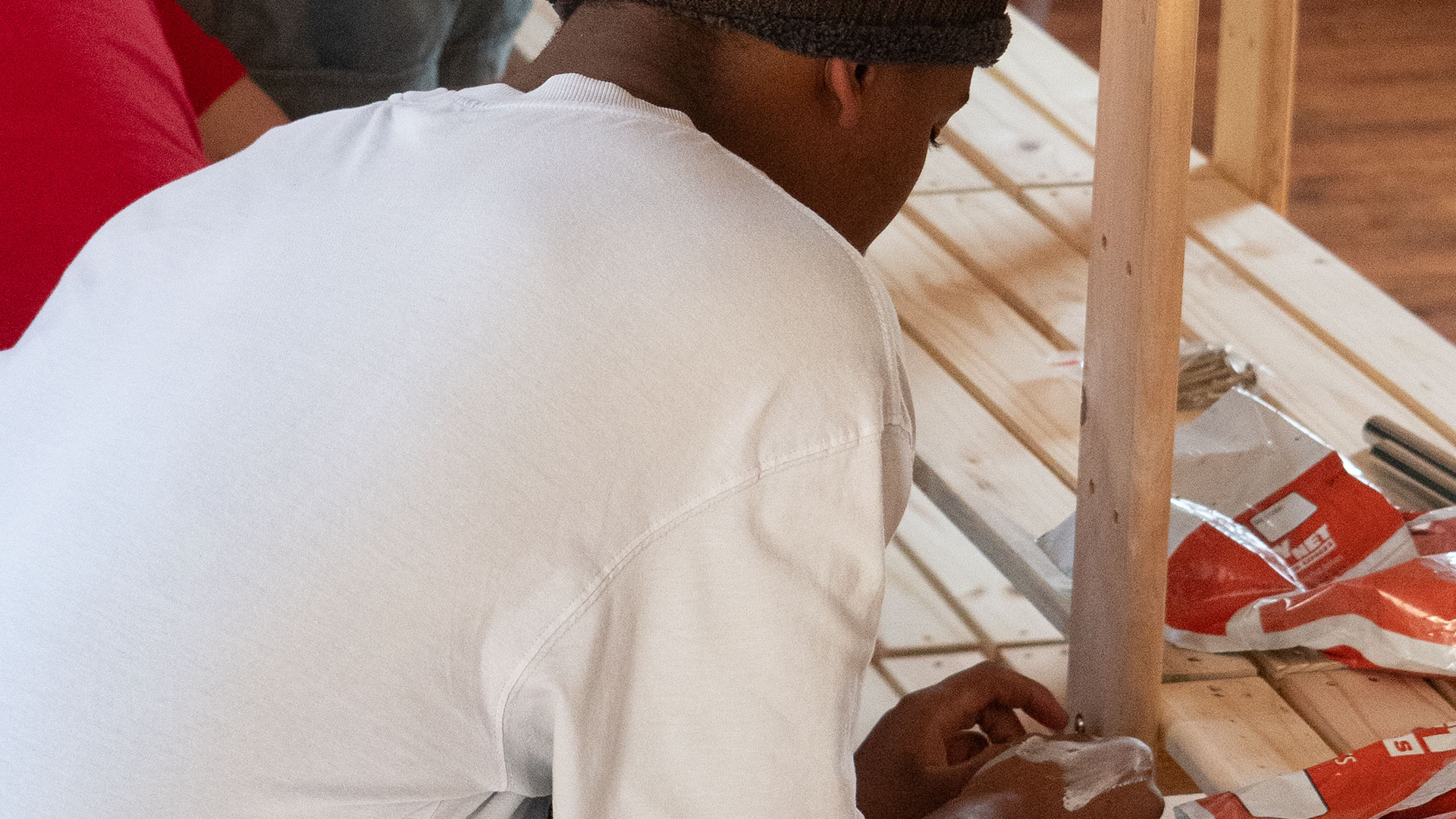Volunteer building a shelf to hold donations.