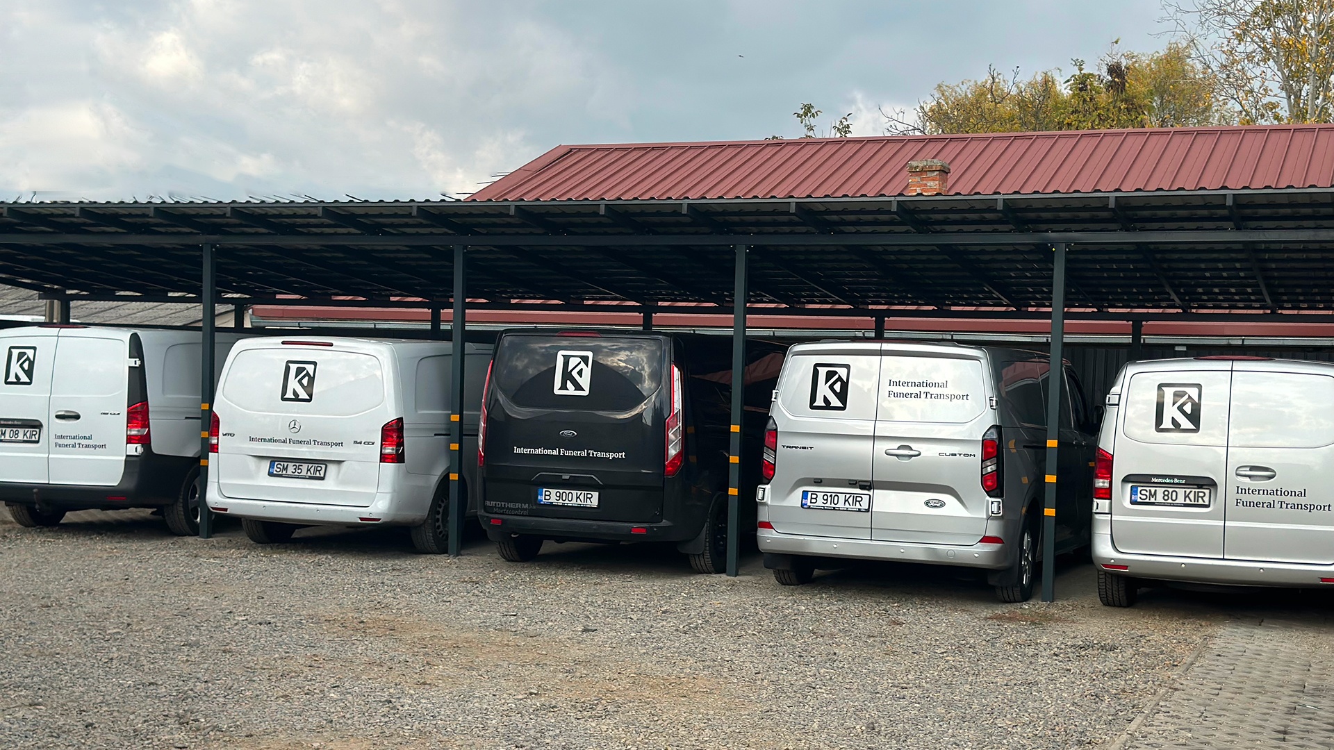 Flota Kirilă Funerar pentru transport funerar internațional, mașini funerare frigorifice inscripționate International Funeral Transport, parcate sub copertină