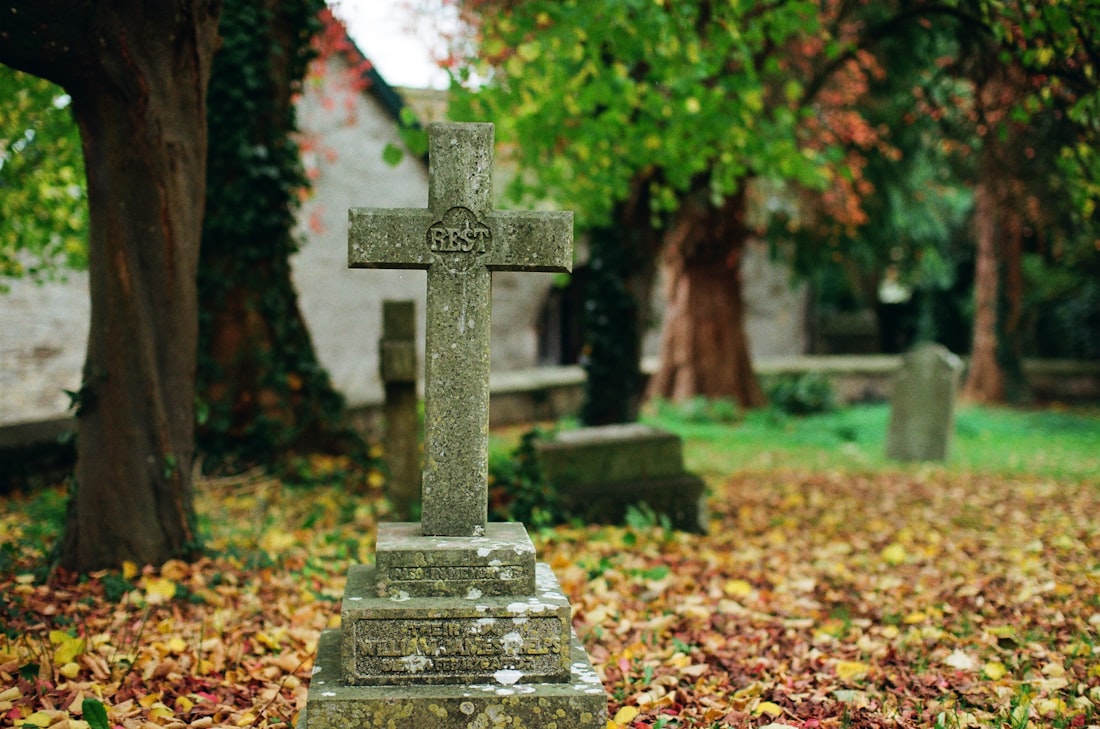 Cruce de piatră într-un cimitir toamna