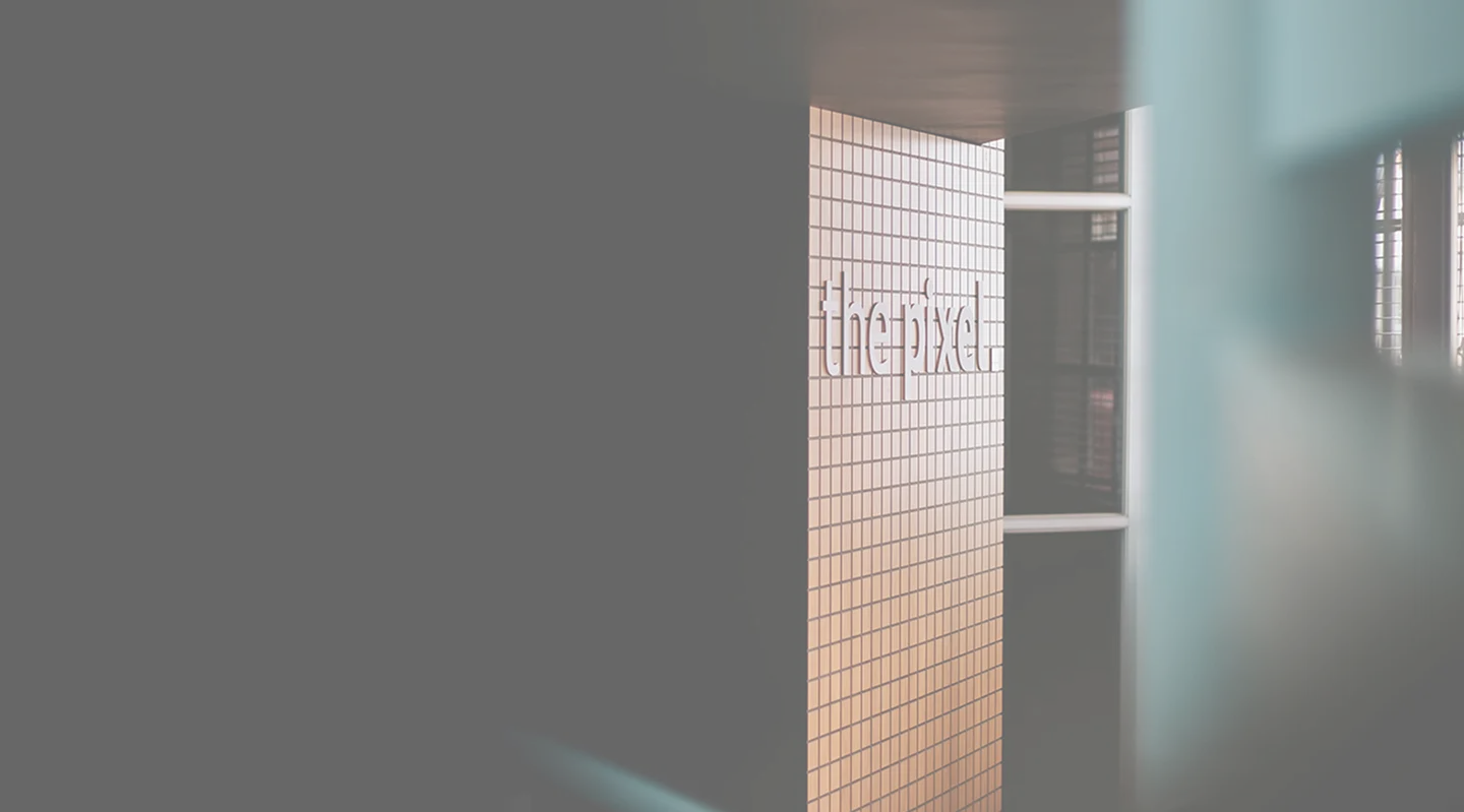 Wall tiled with small square tiles featuring the word 'thepixel' in lowercase letters.