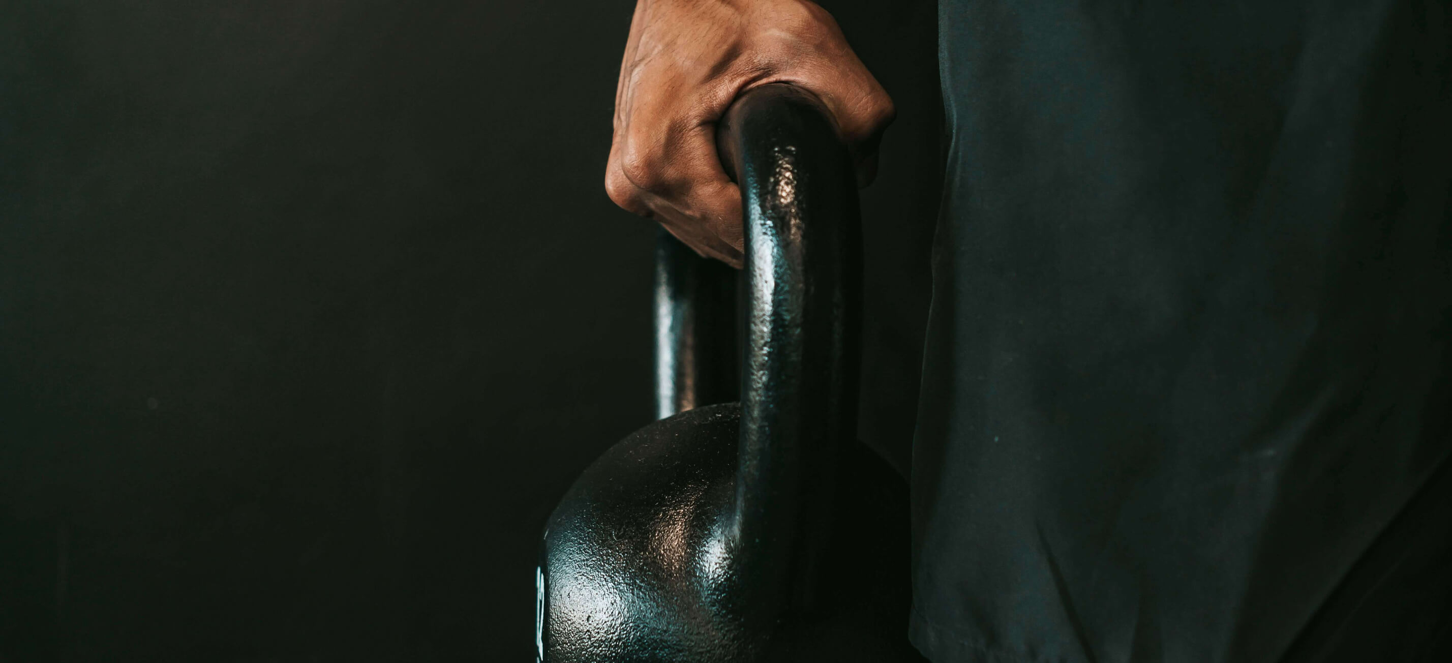 Banner image of a hand holding a training weight.