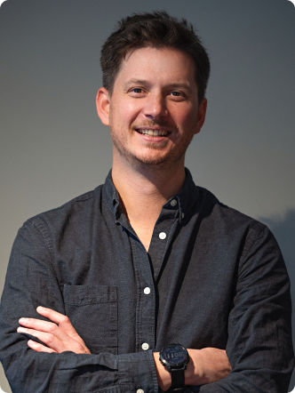 A man wearing a blue shirt with his arms crossed.