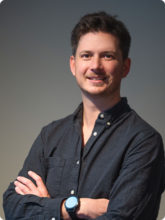 A man wearing a blue shirt and smiling.