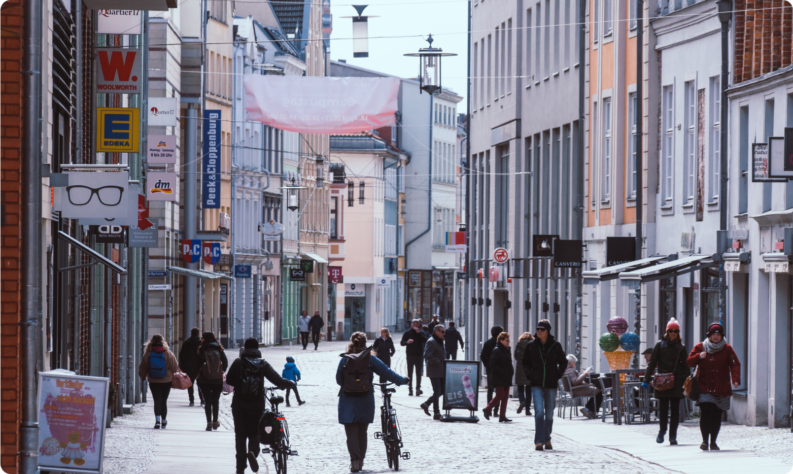 A busy city street with people walking and biking.
