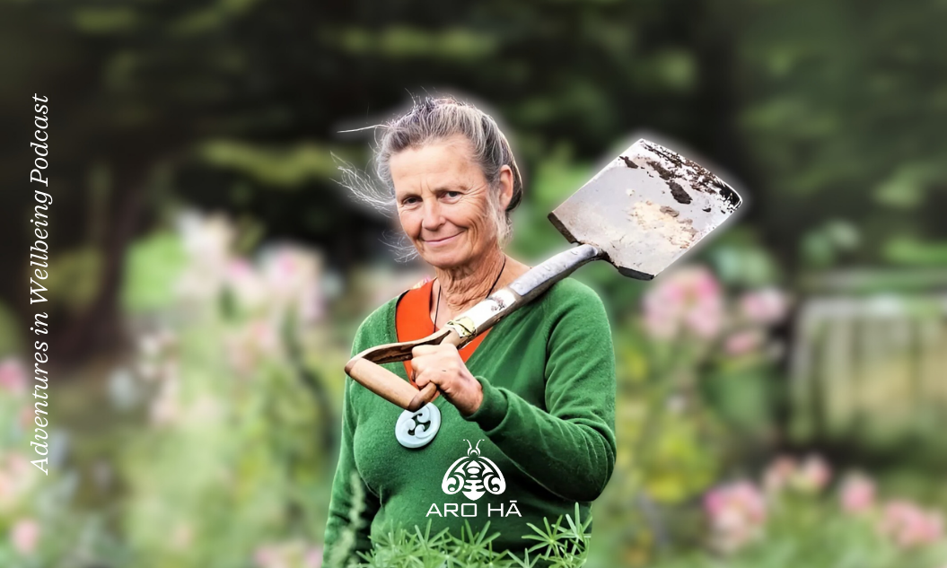 A women walks thru a garden with a shovel on her shoulder