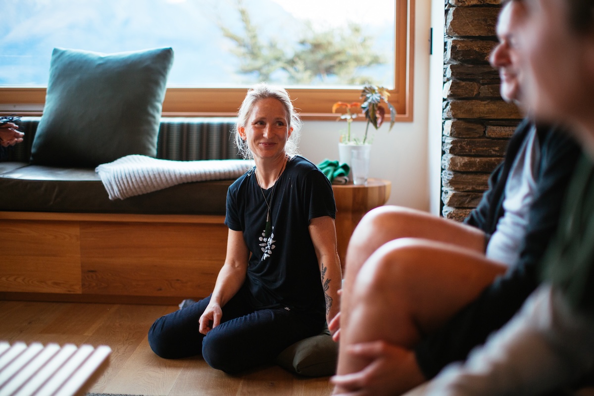 a woman sits on the floor smiling