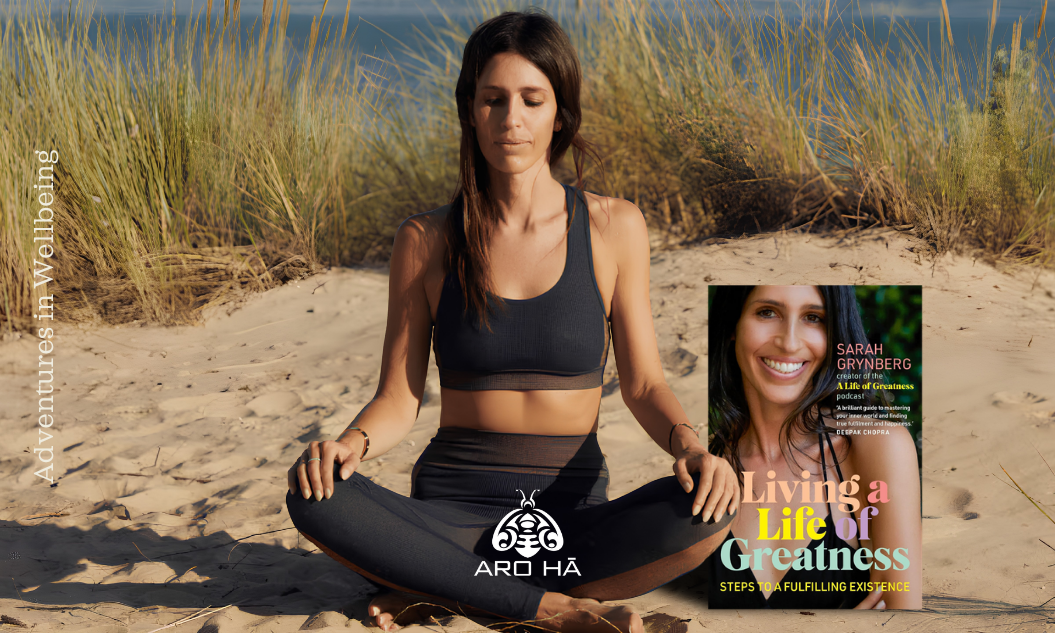 a woman sits cross legged on a beach