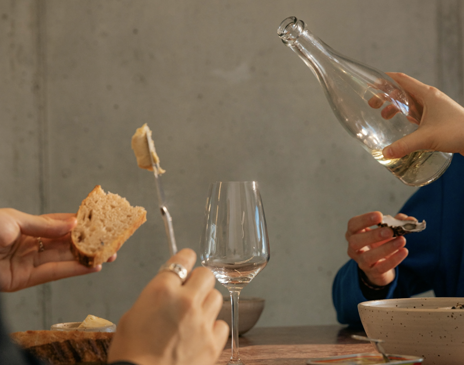 a group of people having food and drinks at a table 