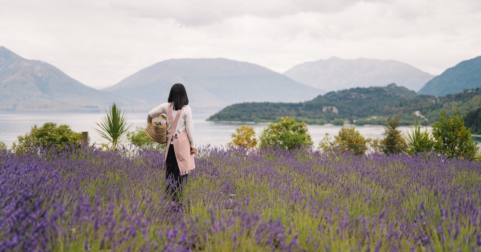 Woman looking over at lake in lavender field