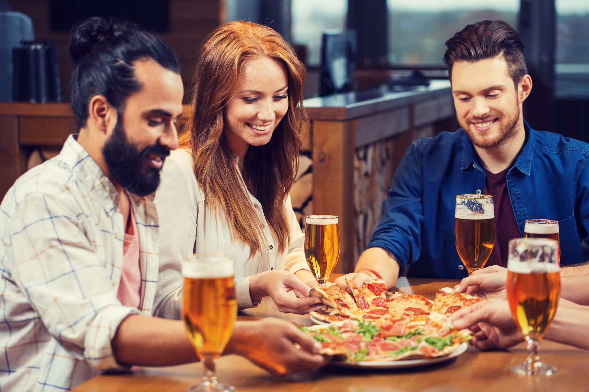 group of friends enjoying pizza and beer together