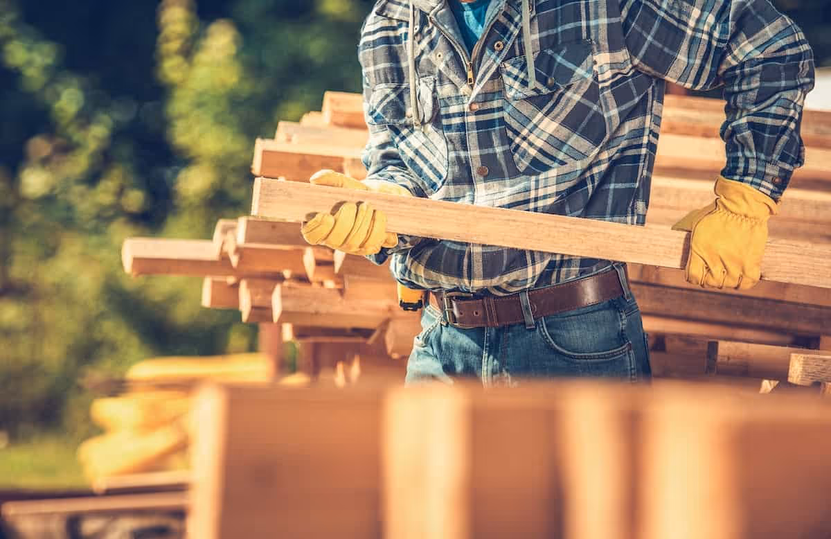 man working in construction with lumber