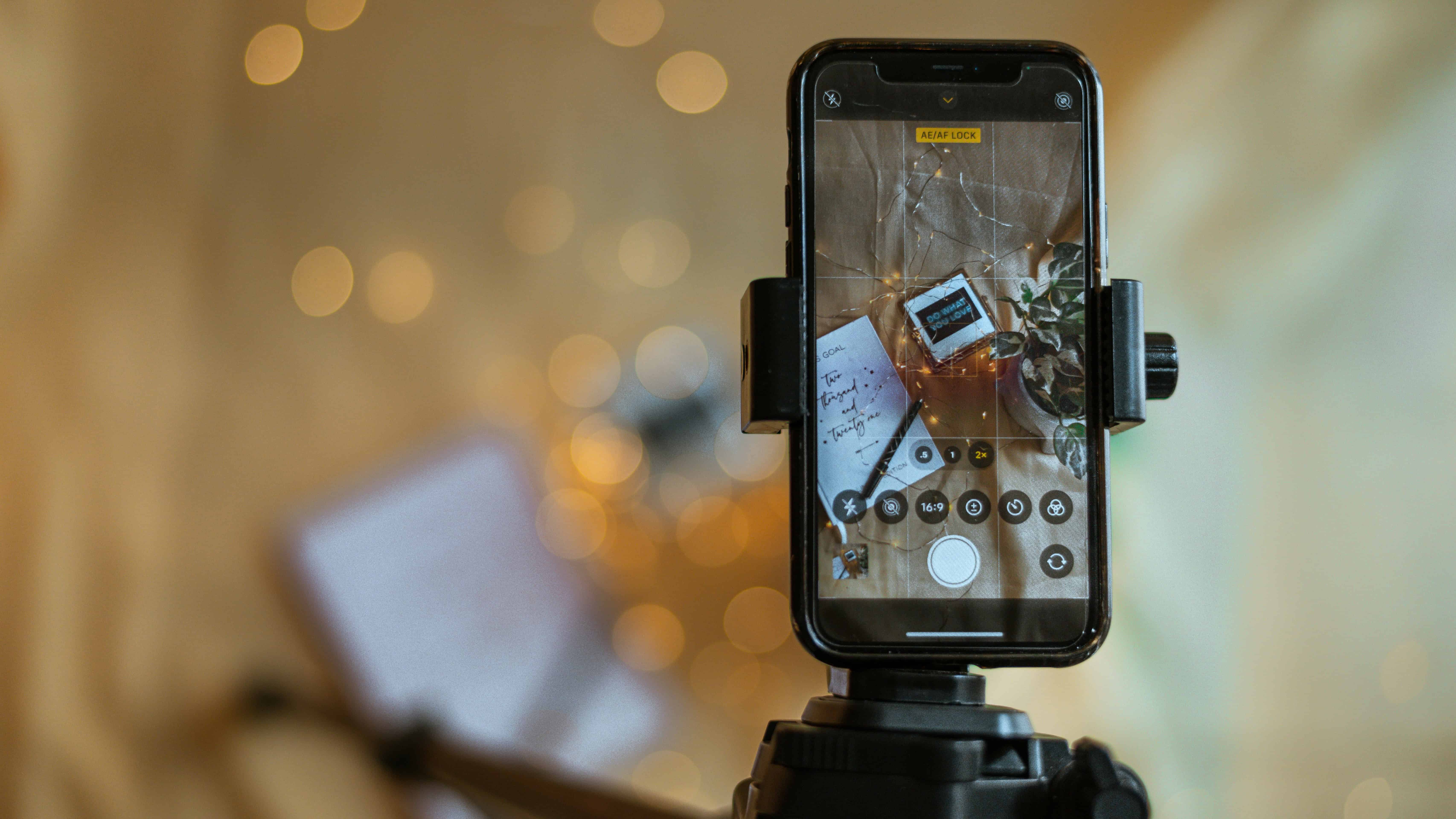 Smartphone on tripod filming DIY video content for small business marketing, showcasing accessible video production setup.