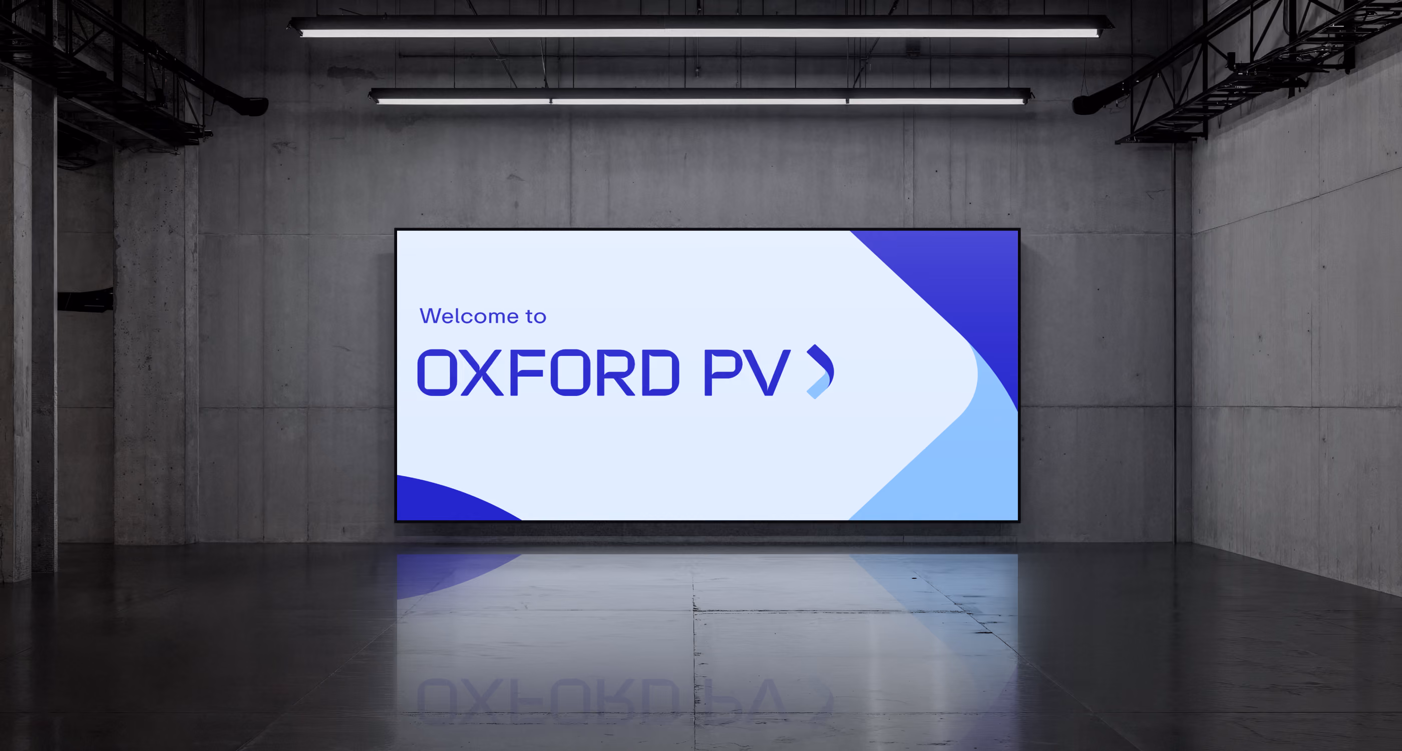 Large digital sign on concrete wall reading 'Welcome to OXFORD PV' in blue text.