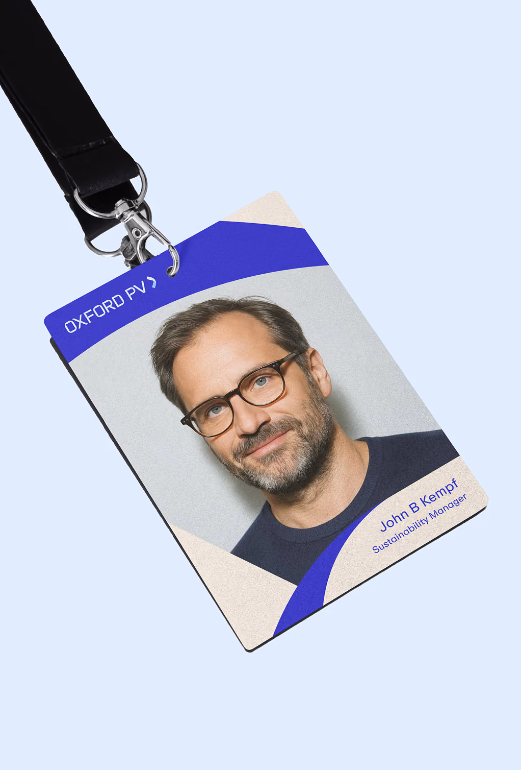 ID badge with a photo of a man wearing glasses labeled John B Kempf, Sustainability Manager.