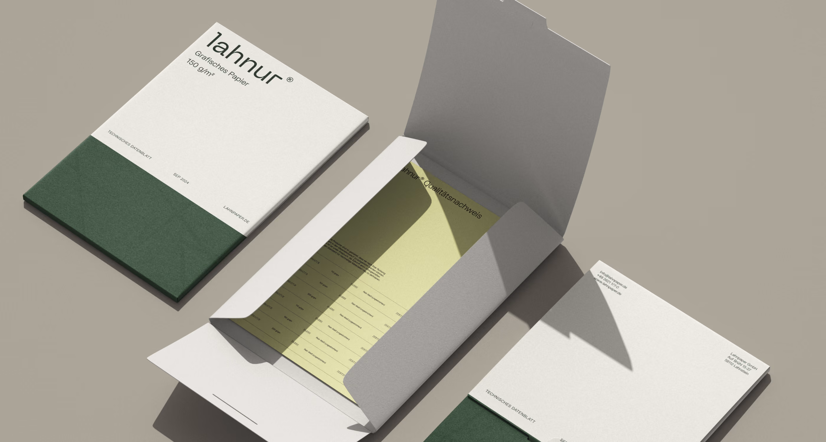 Closed and open white-green folders with documents on a gray surface, one folder reveals a yellow sheet inside.