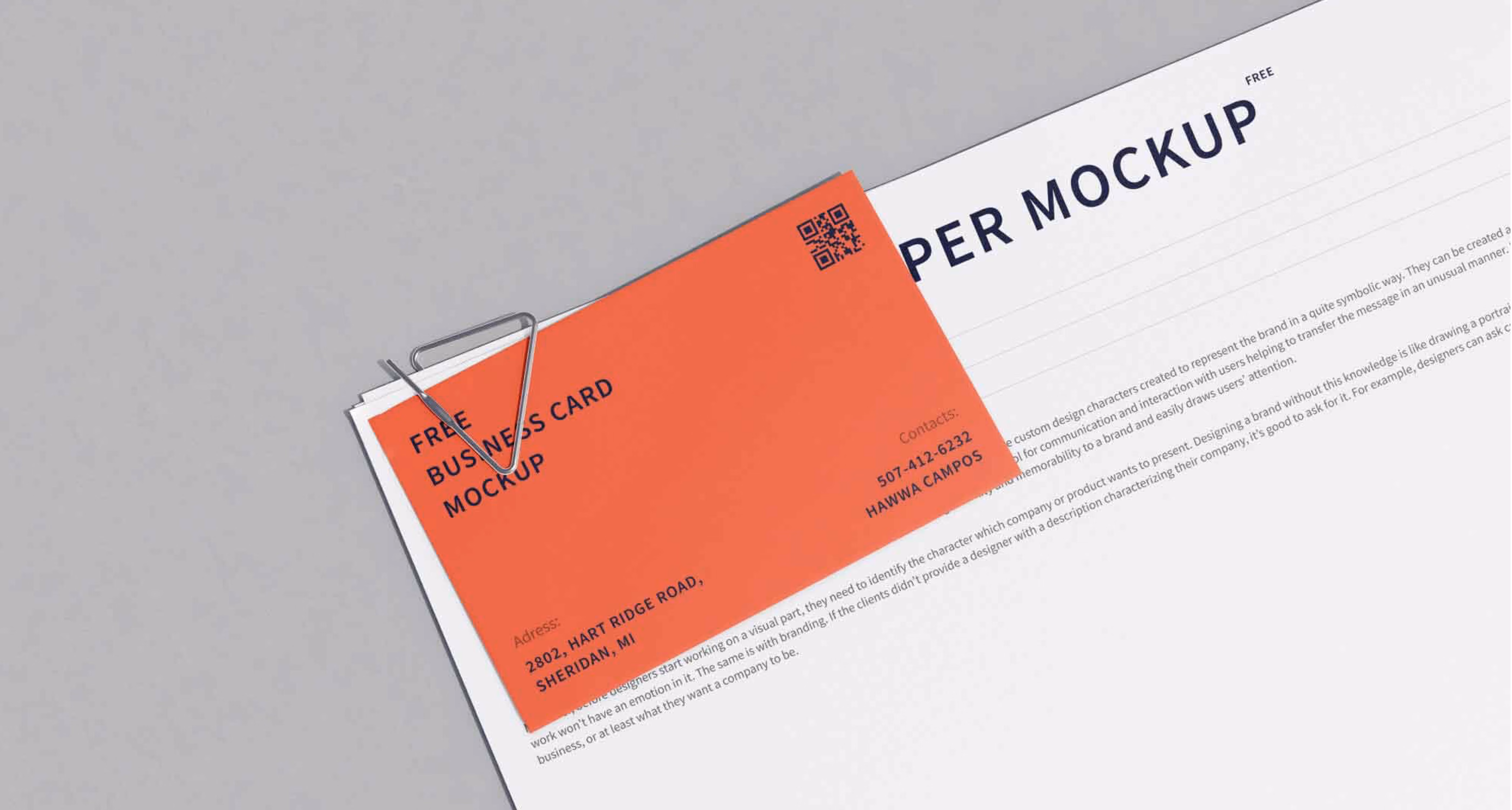 Orange business card clipped to white paper with text titled 'Paper Mockup' on gray surface.