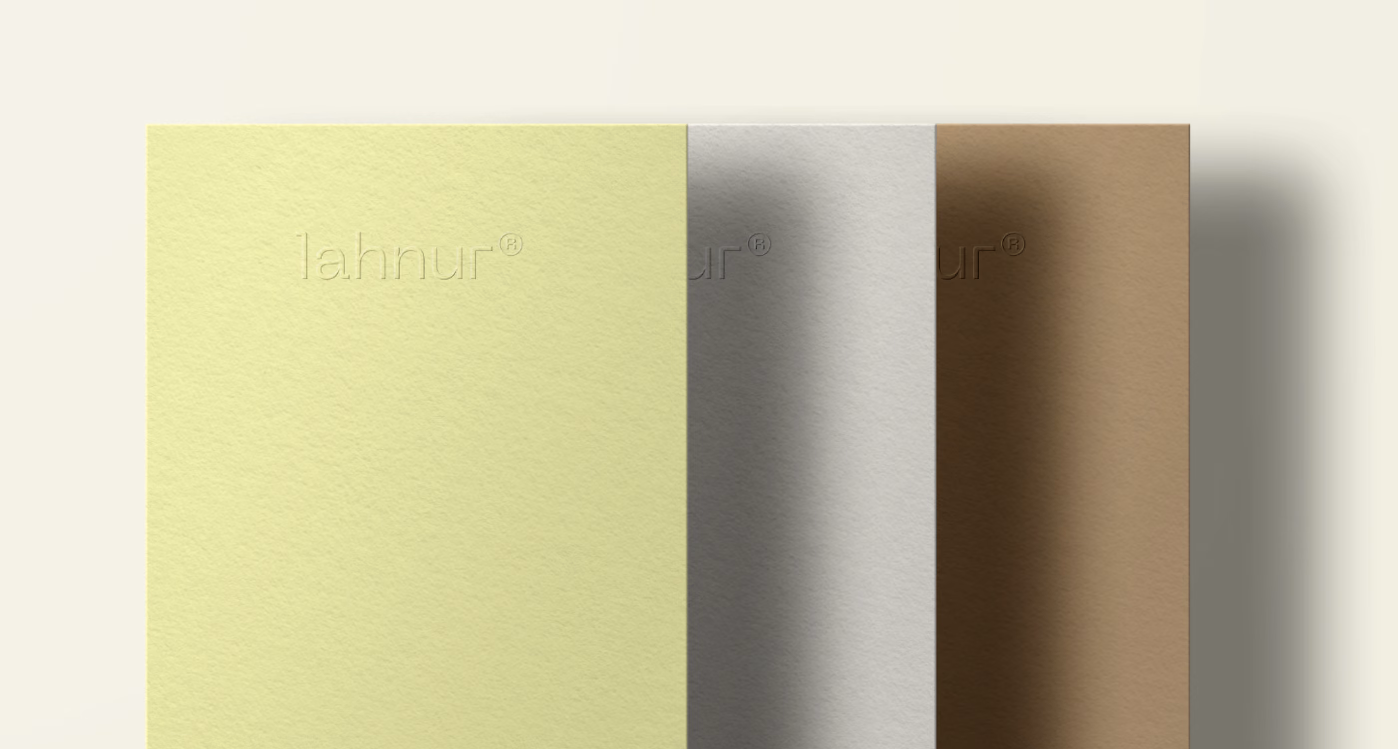 Three textured paper sheets in pale yellow, light gray, and brown arranged side by side.