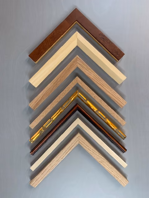 Picture frame corner samples in natural timber, dark wood, white and gilt finishes