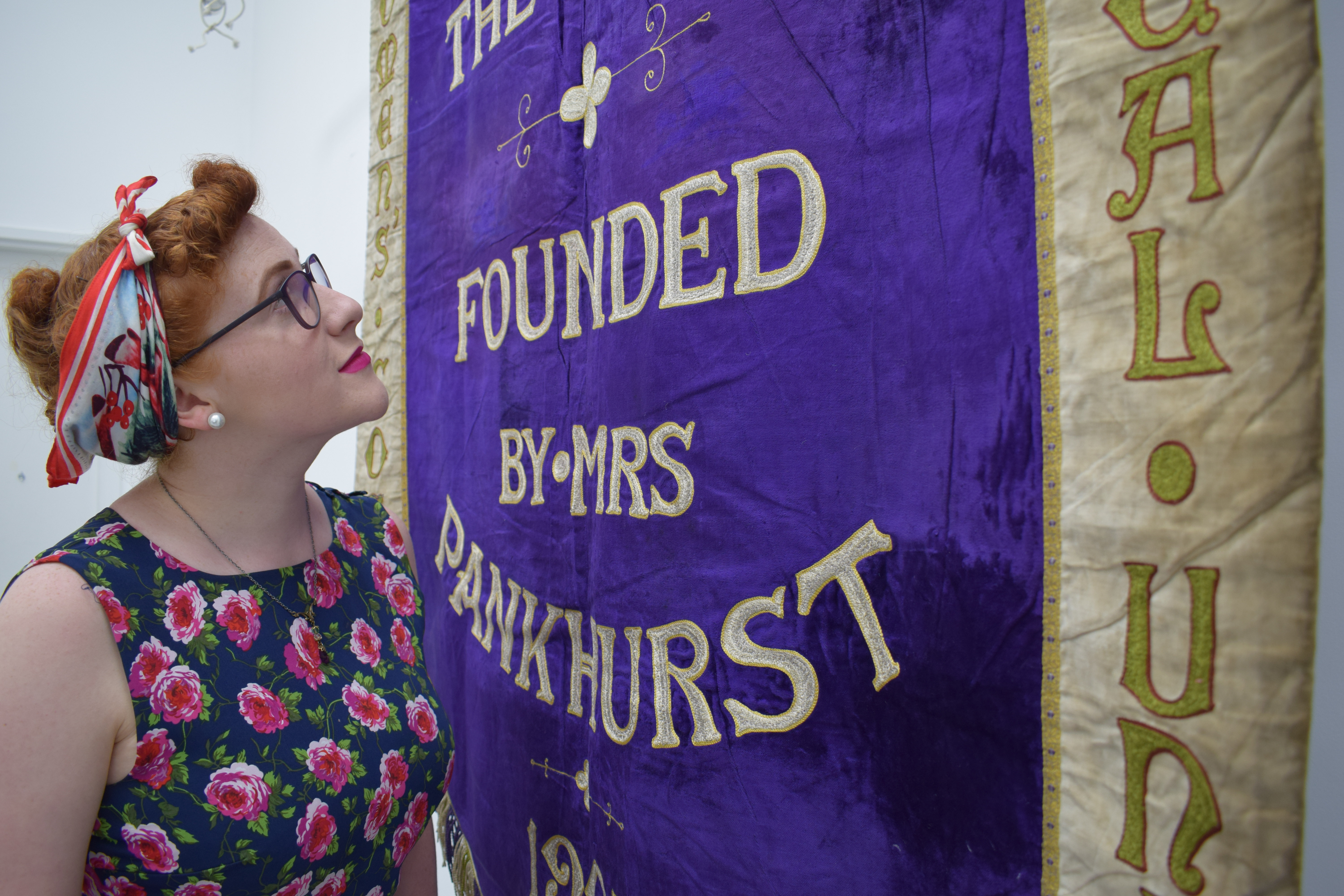 Helen Antrobus, National Trust Assistant National Curator (Social History) with Manchester Suffragette Banner. Image courtesy of People's History Museum