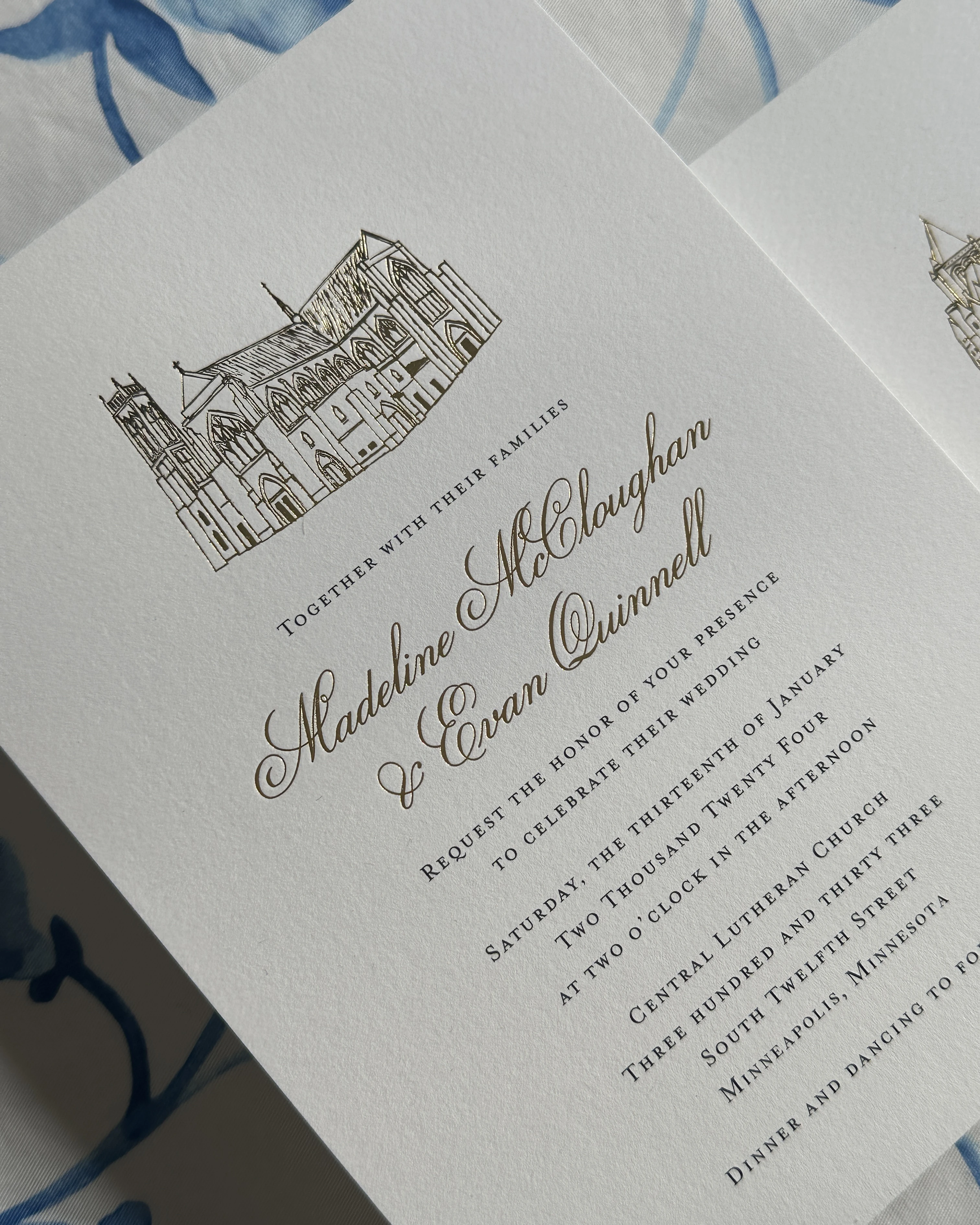 Elegant wedding invitation with gold calligraphy and an architectural illustration at the top.