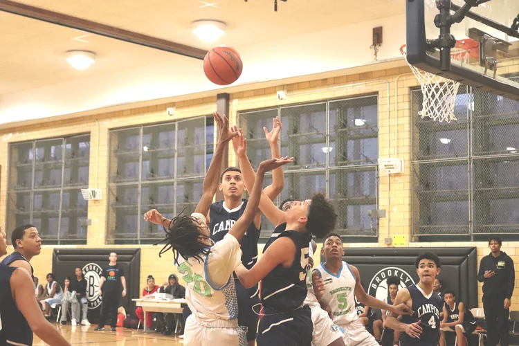 Students competing for rebound during basketball game